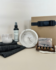 Grooming products including a bottle, bowl, and soap on a neutral background