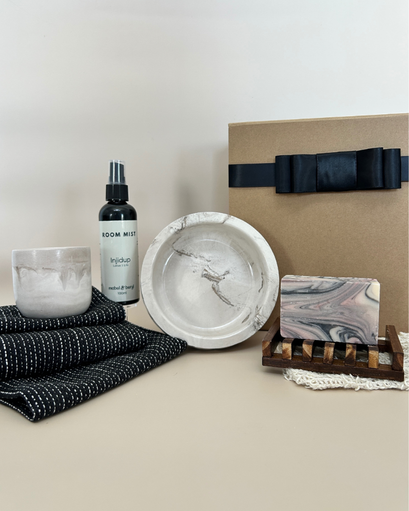 Grooming products including a bottle, bowl, and soap on a neutral background